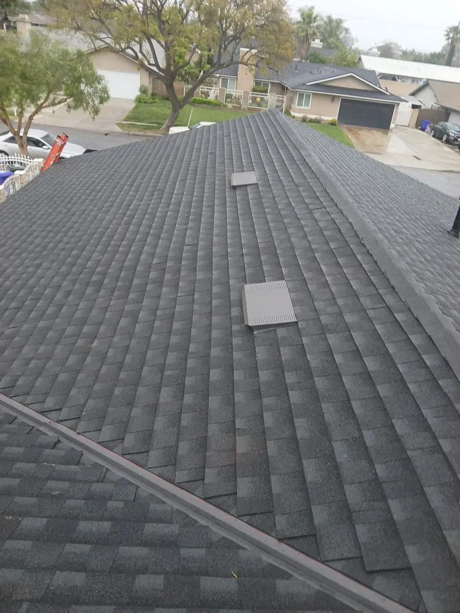 Dark shingle roof with hip lines and several roof vents