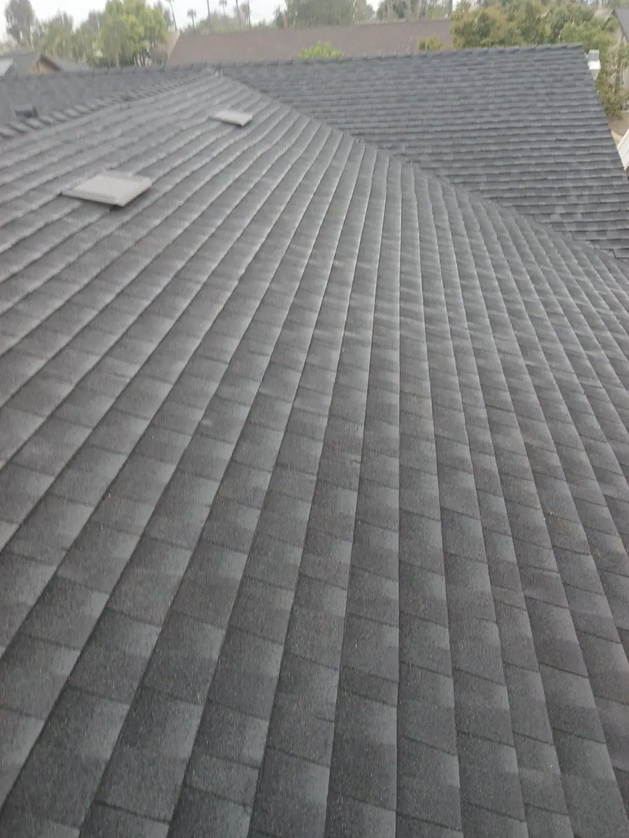 Dark shingles covering a roof slope beneath a ridge