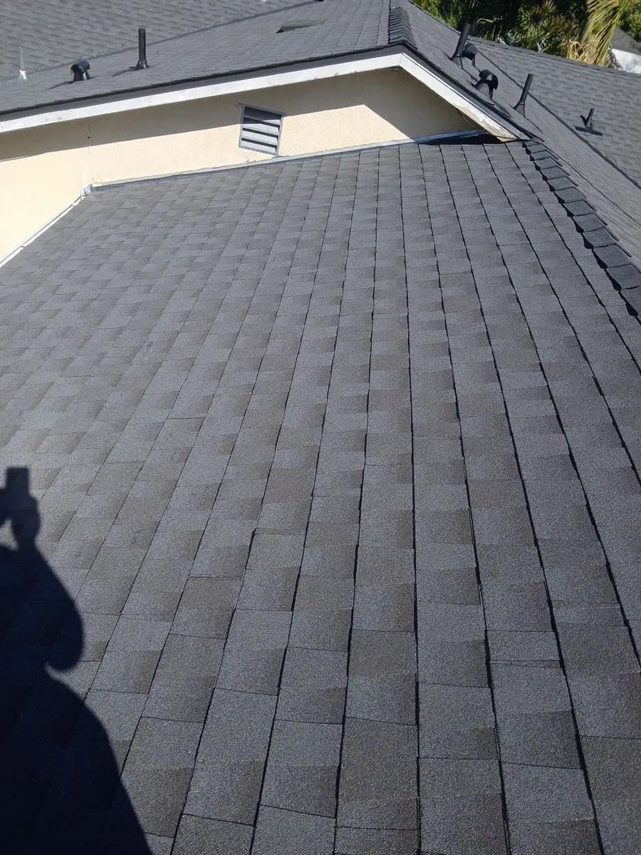 Dark shingles meeting a roof valley beside a light exterior wall