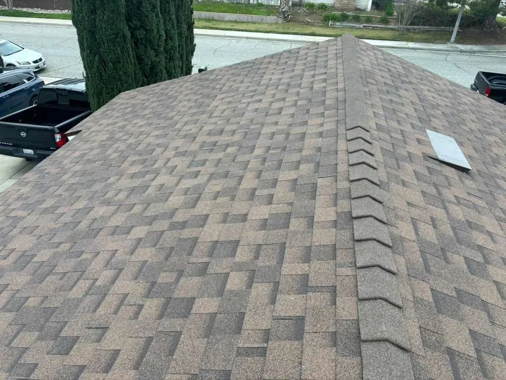 Dimensional asphalt shingles with a hip ridge and a rectangular roof vent