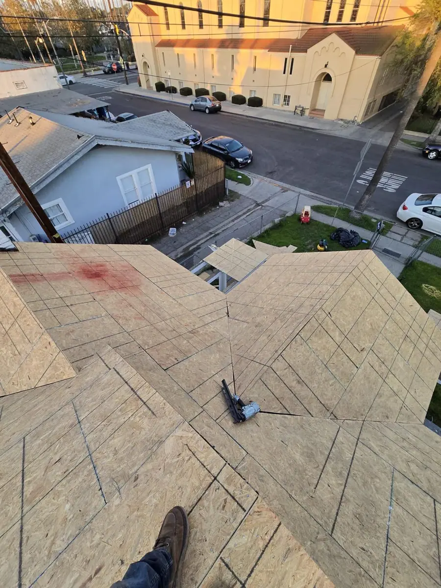 Marked wood roof decking with a tool resting on the surface