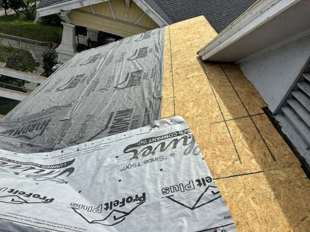 Printed underlayment adjoining exposed wood decking near a roof-to-wall transition