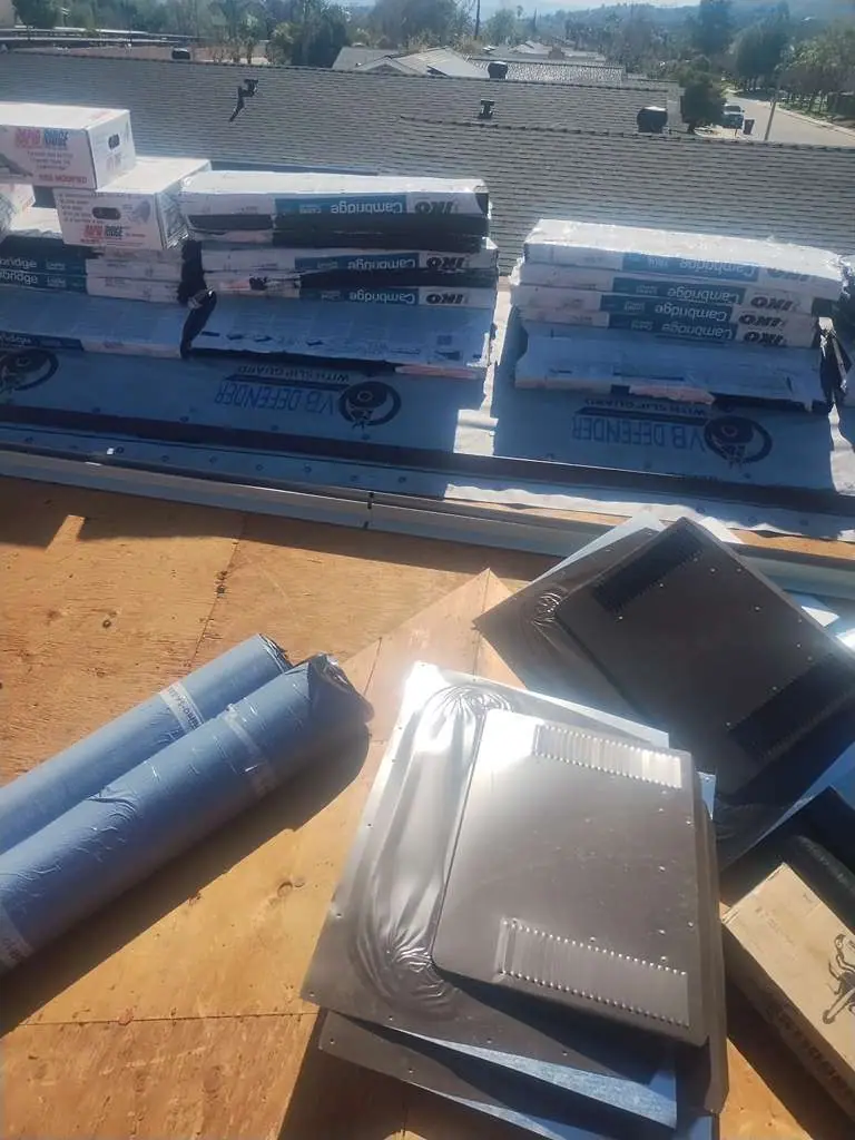 Metal roof vents and packaged materials resting on a roof assembly