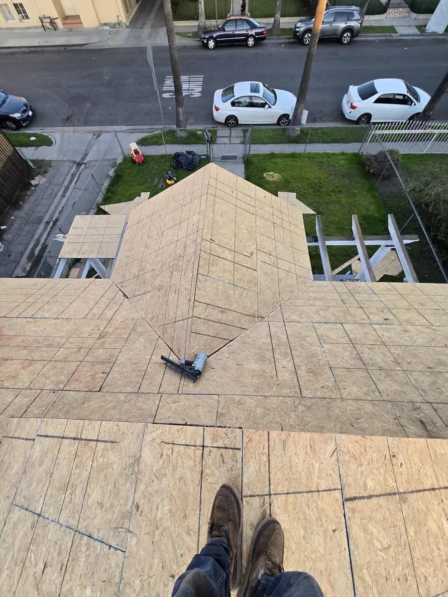 Wood roof deck panels on connected slopes with a vent penetration