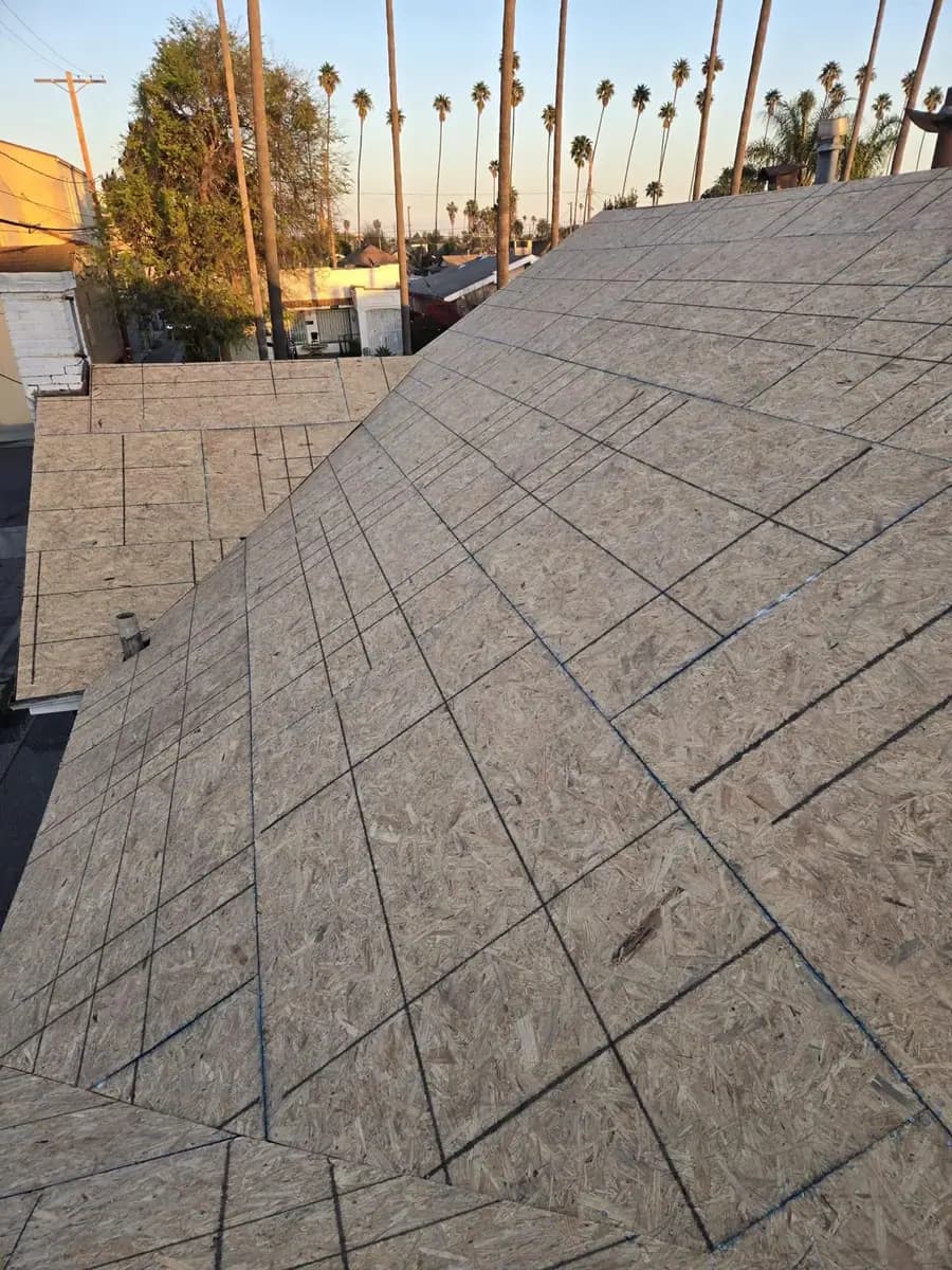 Exposed wood roof deck with marked lines and a vent pipe
